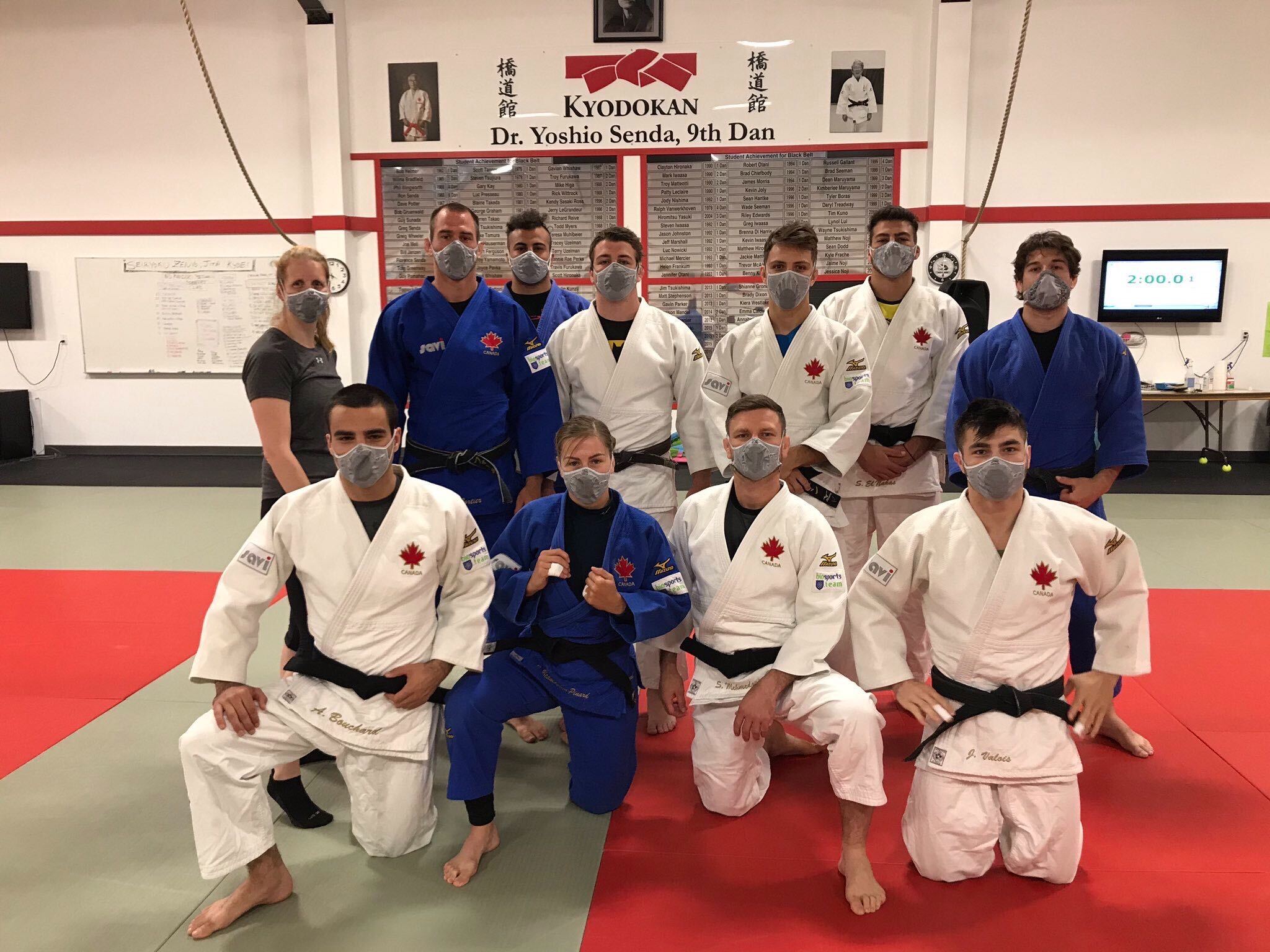 Judo national team members pose wearing masks in the dojo