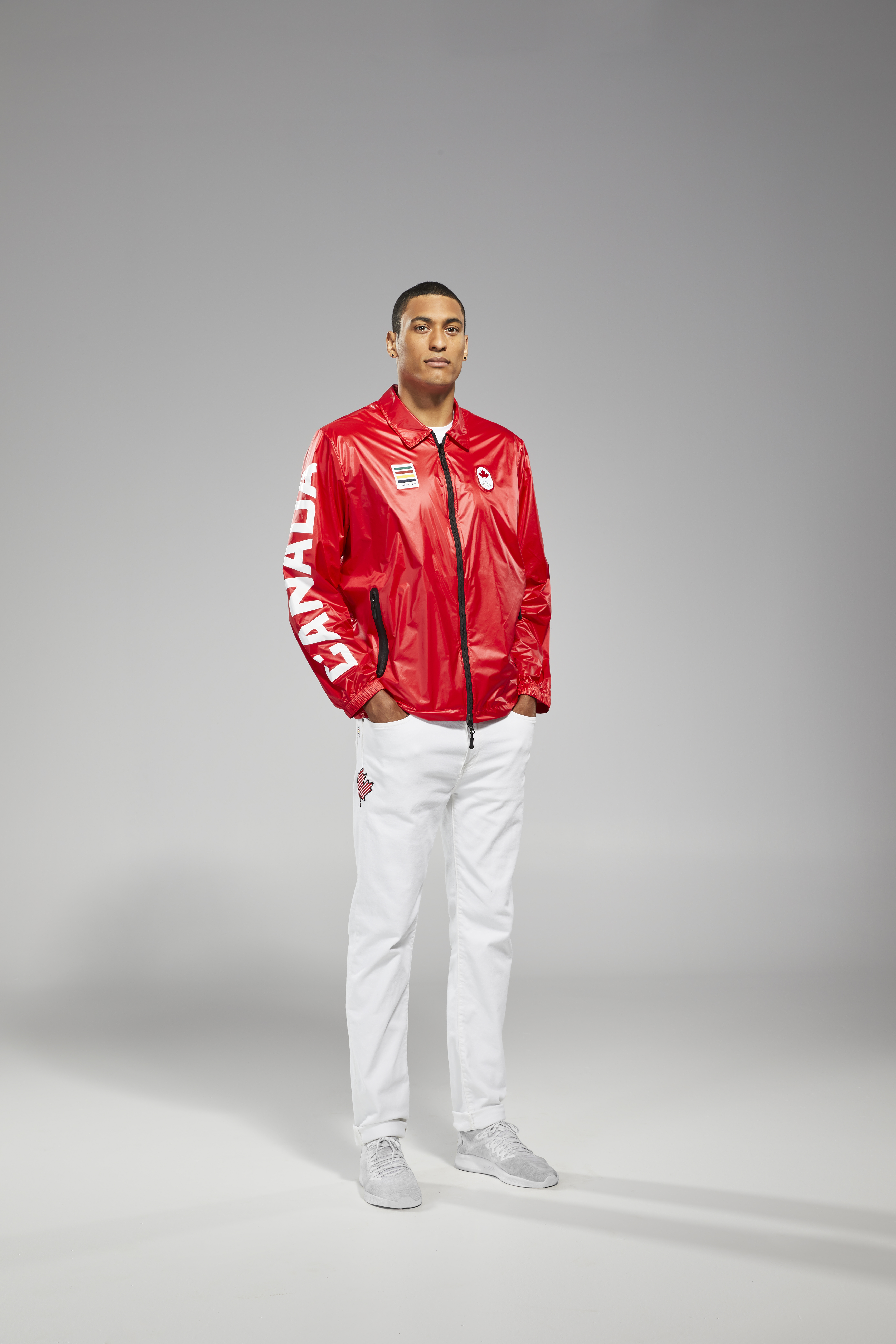 Lepage hands in pocket with red jacket and white pants looking at camera