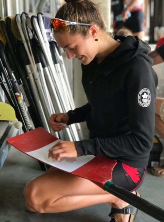 Avalon Wasteneys Avalon Wasteneys affixes a maple leaf sticker to her oar