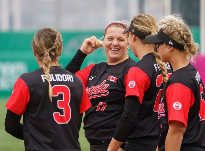 Members of women's softball team talking in a huddle