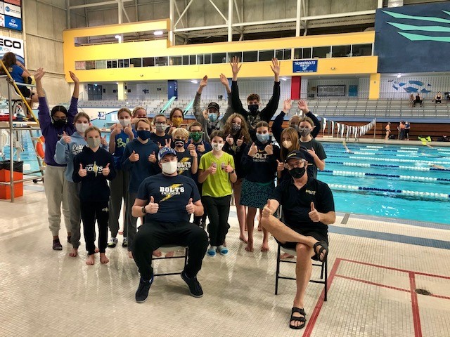 Swimmers on pool desk cheering 