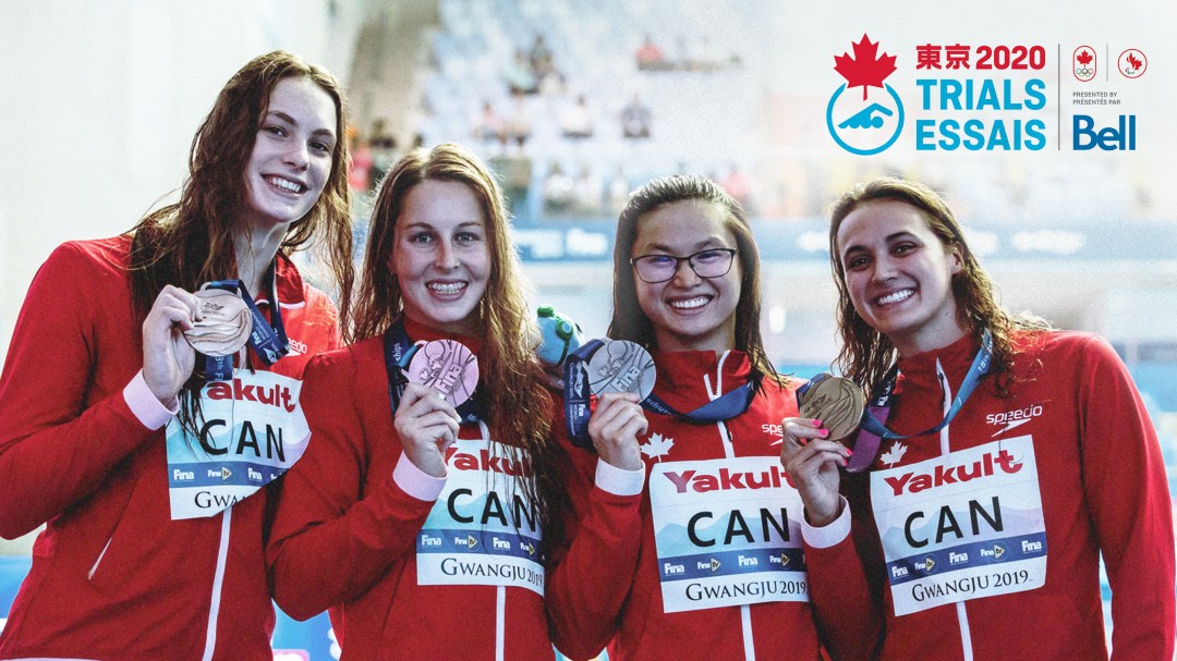 Four swimmers pose for the camera with medals