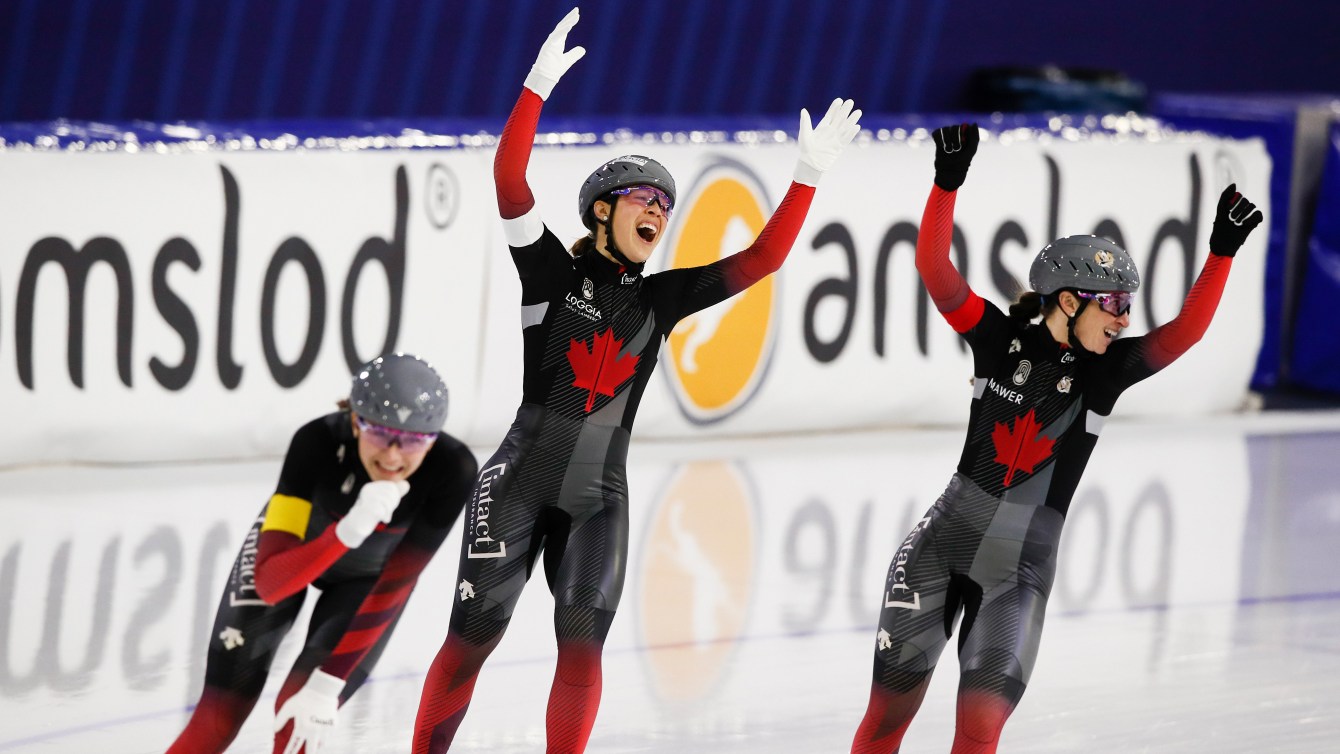 Valerie Maltais, center, Ivanie Blondin, right, and Isabelle Weidemann, left, celebrate setting a new track record and winning the women's team pursuit race.