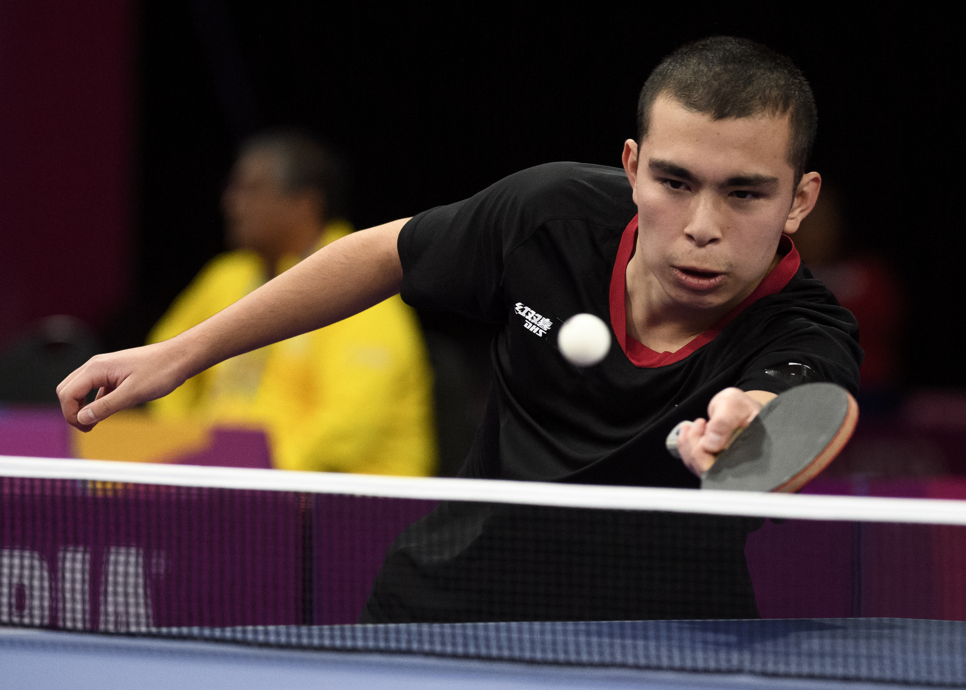 Male table tennis player prepares to return the ball 