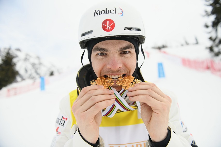 Mikaël Kingsbury takes a bite of his two gold medals.