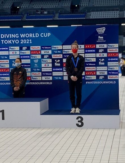 Caeli McKay stands on bronze medal step of podium
