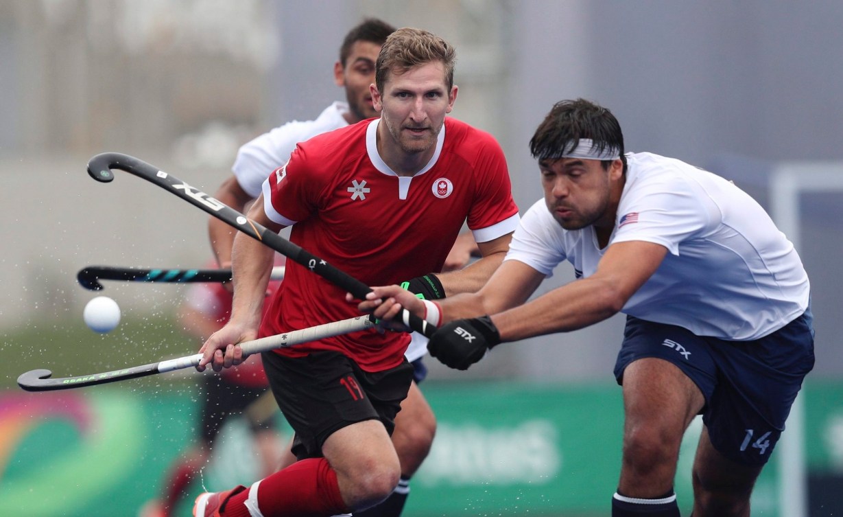Hans Kaeppeler of the United States, right, and Mark Pearson of Canada compete for control of the ball during the field hockey men's preliminaries group B match at the Pan American Games in Lima, Peru, Thursday, Aug. 1, 2019. (AP Photo/Martin Mejia)