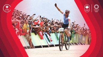 Cyclist raises arm while crossing finish line