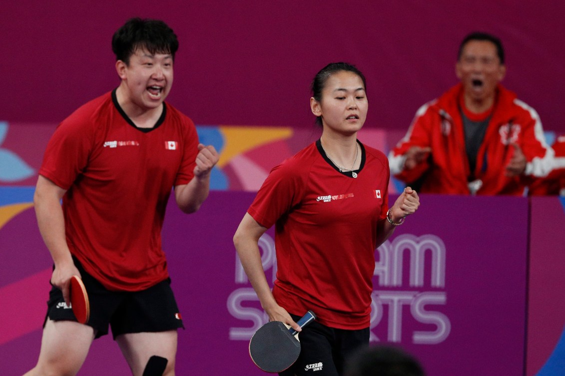 Eugene Wang, left, and Mo Zhang, center, celebrate at the Pan American Games in Lima, Peru.