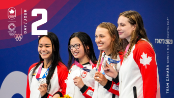 Four swimmers smiling on podium