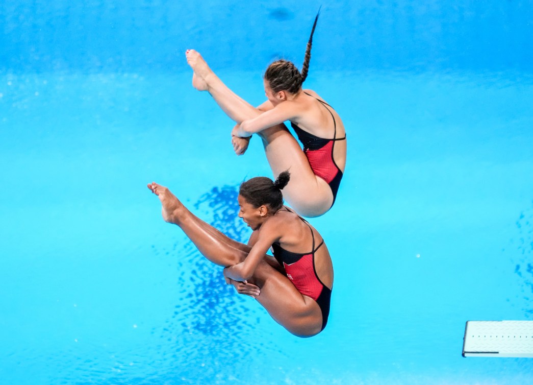 Two divers in the air in pike position