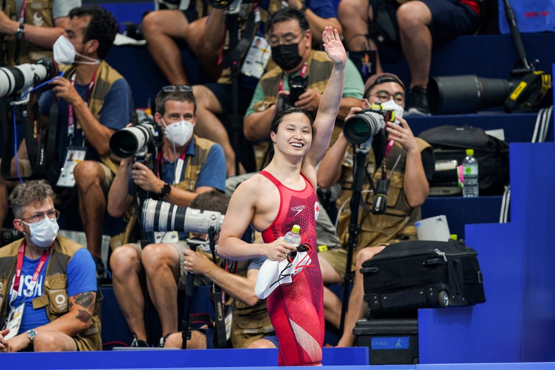 Maggie MacNeil waves in front of cameras