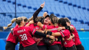 Canadian women's softball team celebrates in a huddle