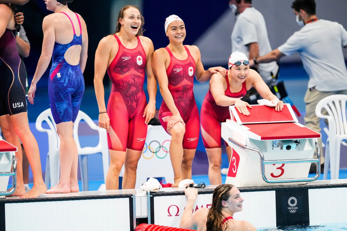 Canadian swimmers celebrate on pool deck 