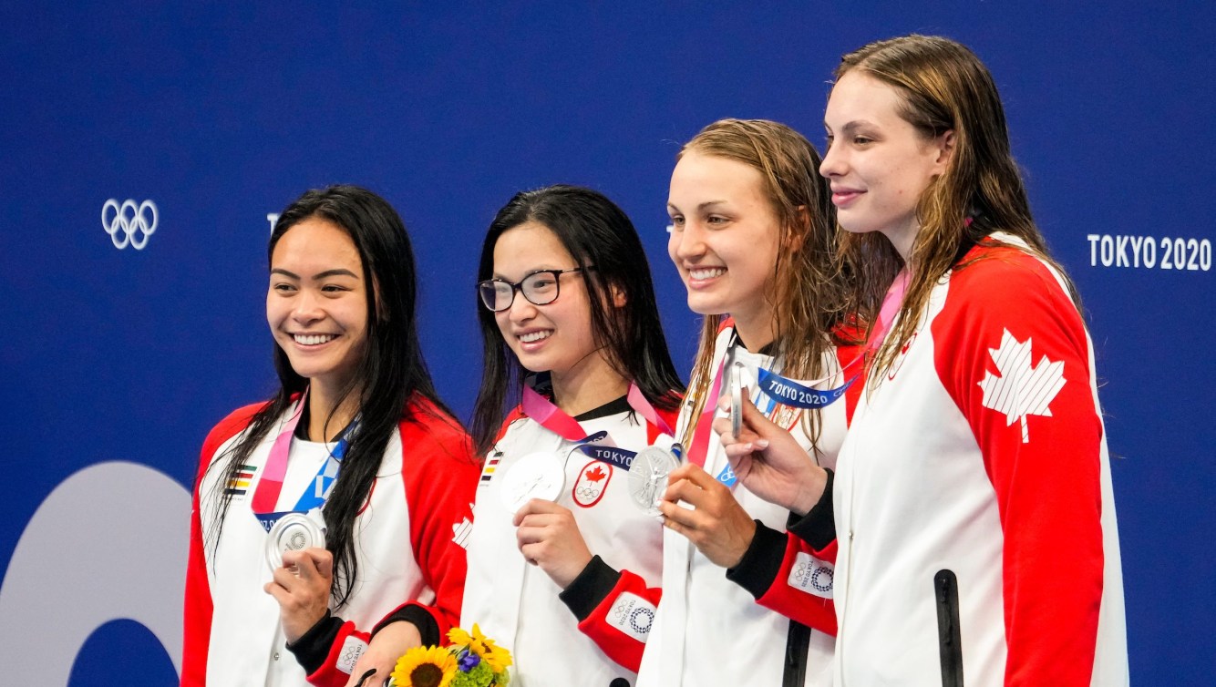 Canada's freestyle relay team smiles on the podium