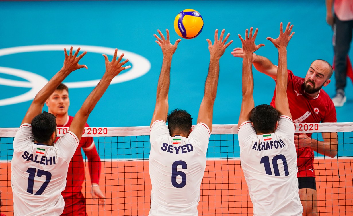 Volleyball player spikes ball