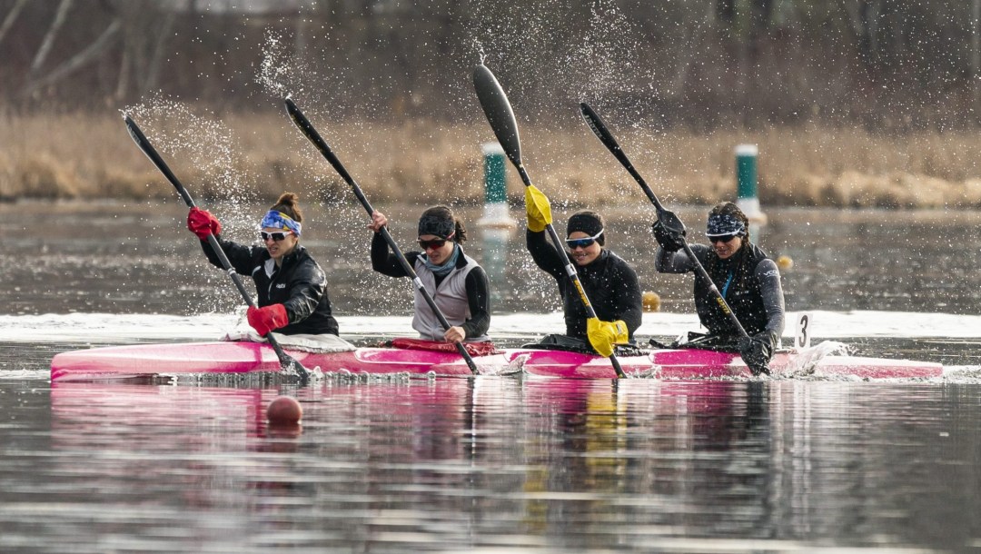 Four female kayakers paddling in their boat