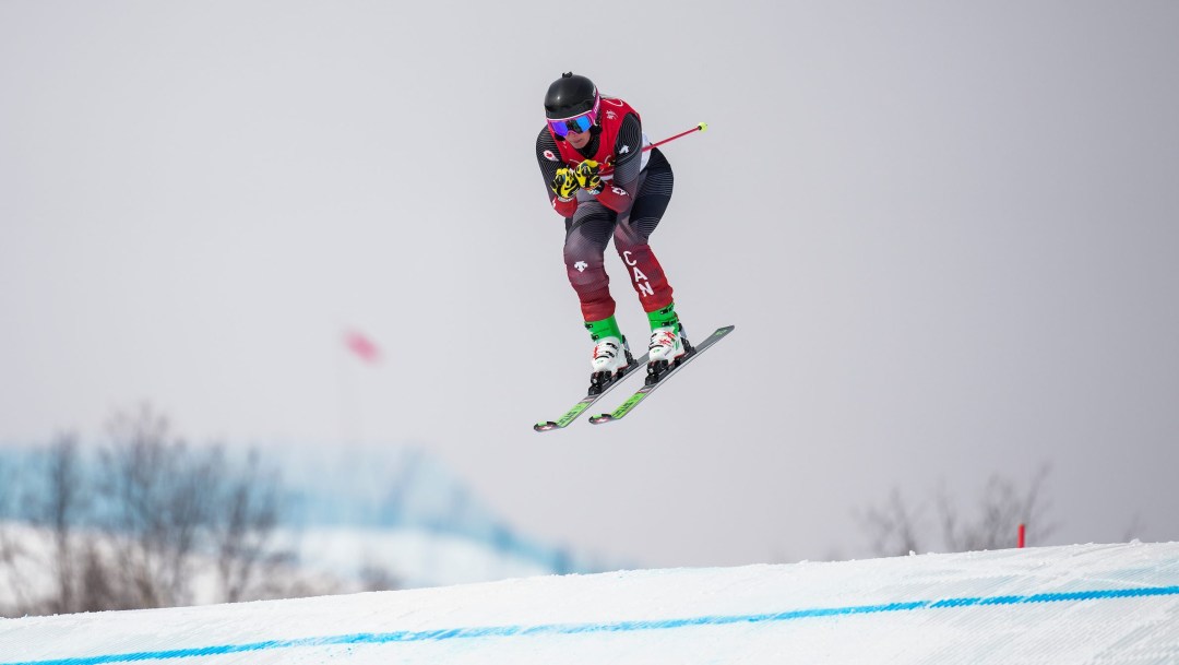 Marielle Thompson flies in the air over a bump on a ski cross course