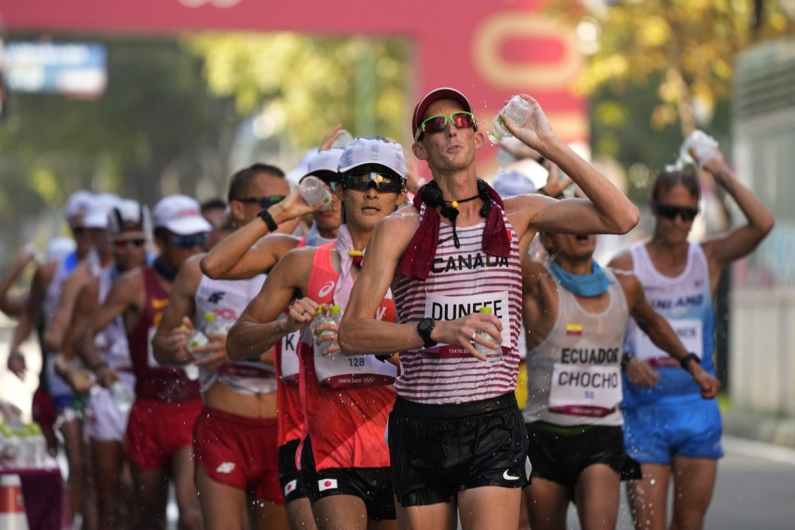 Evan Dunfee pours water over himself during the 50km race walk