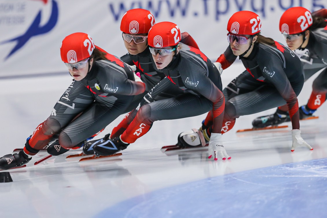 Short track speed skaters racing in a pack