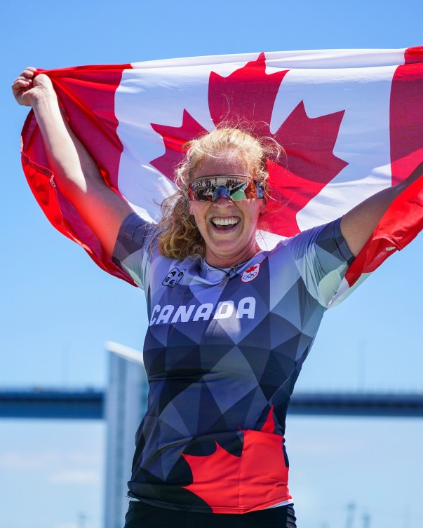 Laurence Vincent Lapointe holds the Canadian flag above her head