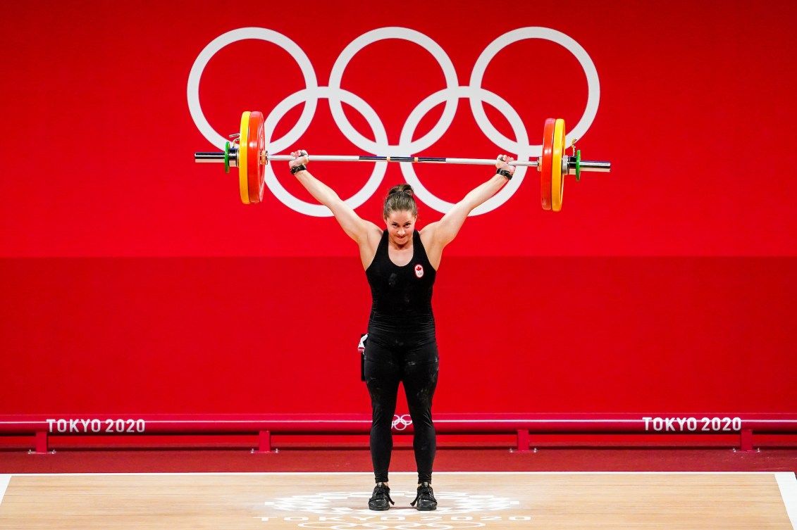 Maude Charron with the bar bell lifted above her head 