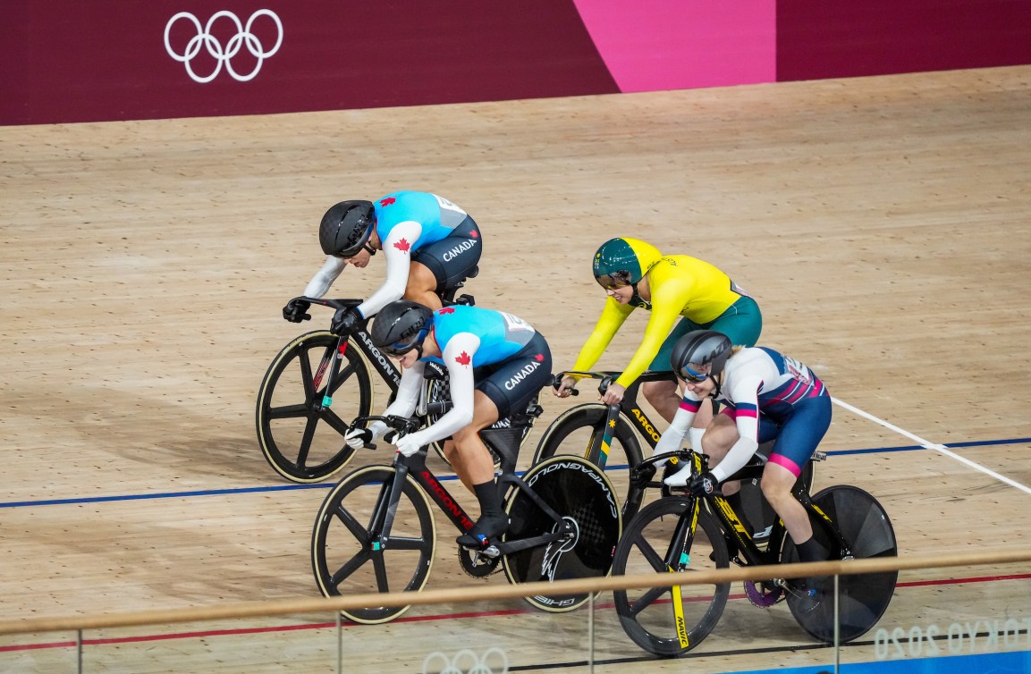 Kelsey Mitchell and Lauriane Genest edge out a competitor at the track cycling finish line 