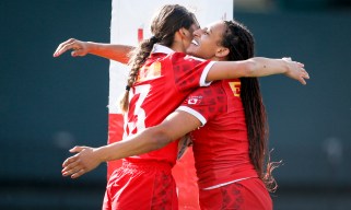 Canada's Kiri Ngawati celebrates with teammate Olivia De Couvreur on the rugby pitch