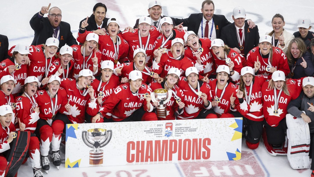 Canadian women's hockey team poses with the sign about being 2021 World Champions