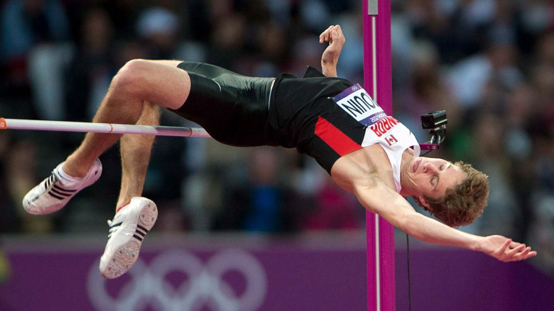 Derek Drouin jumps over a high jump bar