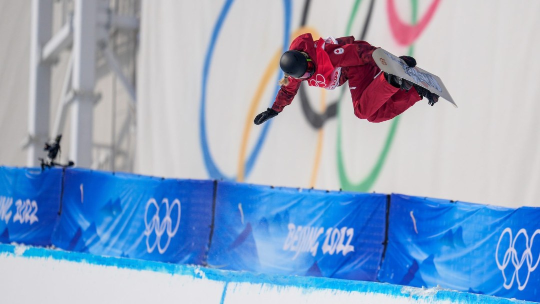 Brooke D'Hondt grabs her board while doing a trick in the halfpipe