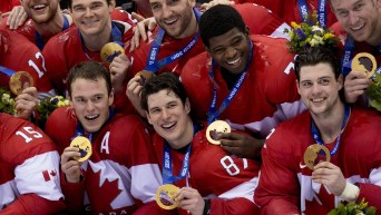 Team Canada men's hockey players pose with their gold medals around their necks