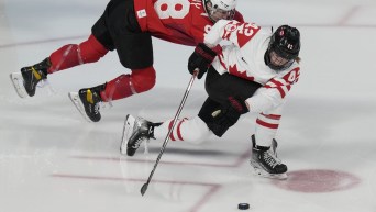 Claire Thompson moves the puck ahead of a Swiss player