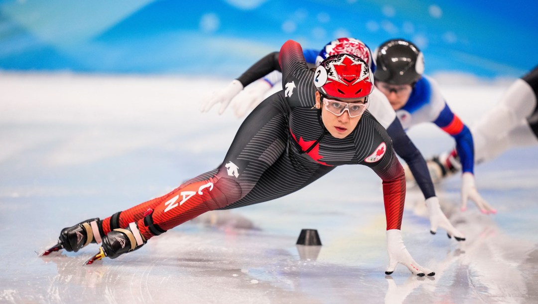 Courtney Sarault leans as she goes around a turn in a short track speed skating race