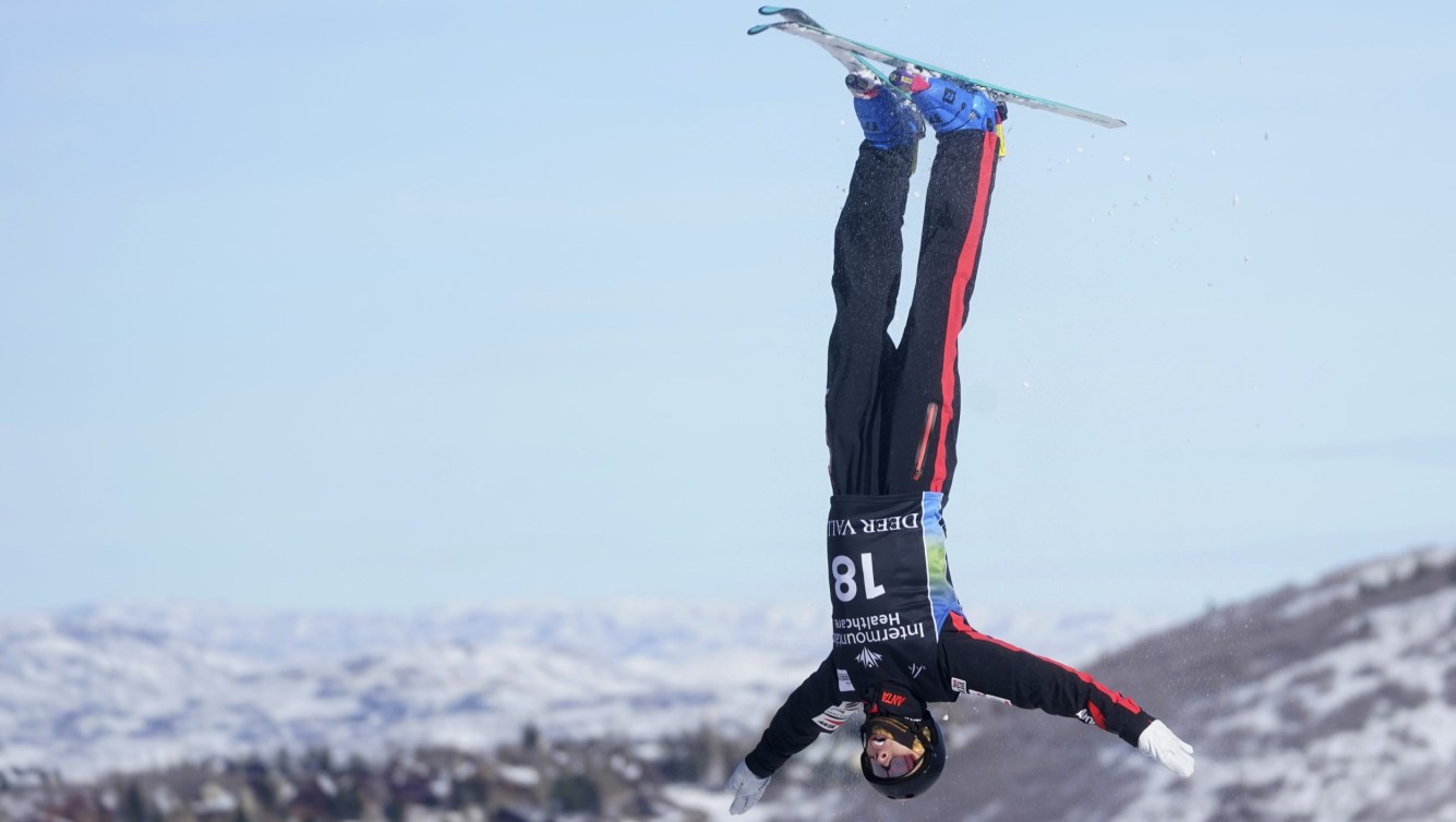 Emile Nadeau upside down in the air while competing in aerials