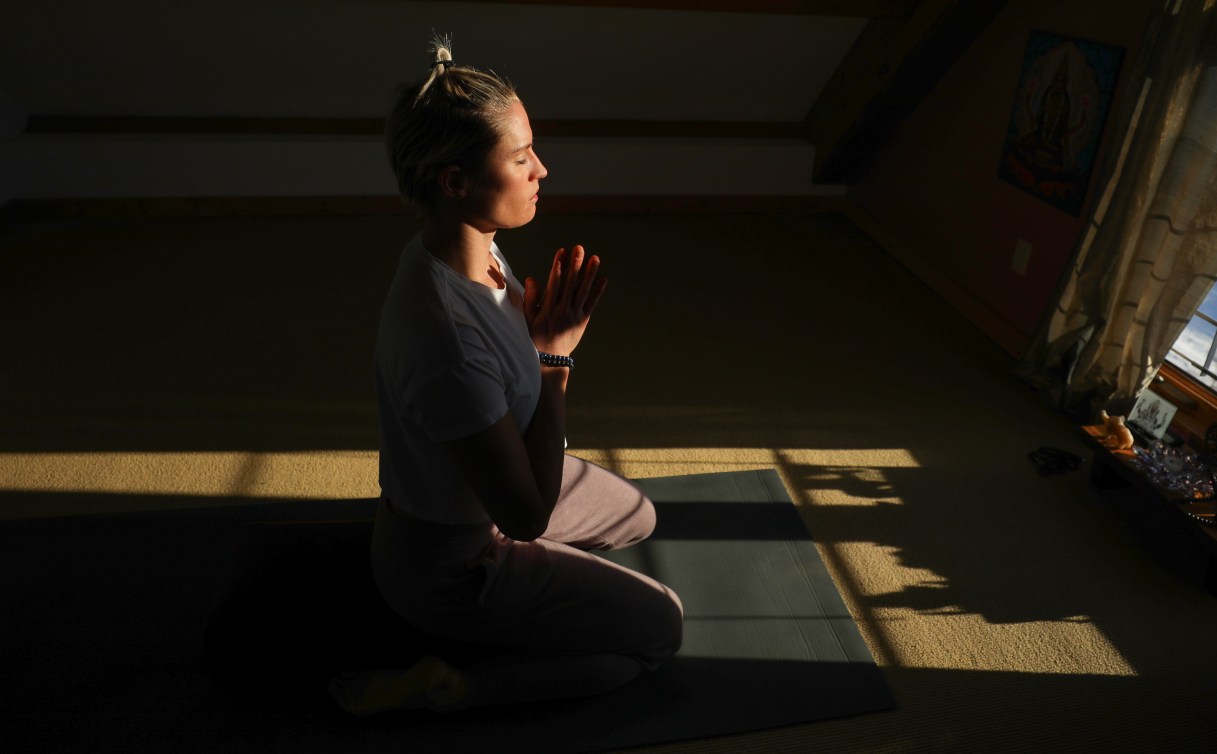 Georgia Simmerling meditates in front of a window 