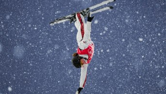 Naomy Boudreau Guertine flips upside down in the air in snowfall