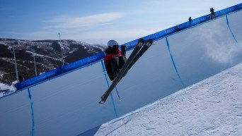 Rachael Karker grabs her ski while doing a trick in the halfpipe