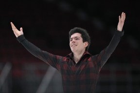 Keegan Messing raises his arms to bow after his program