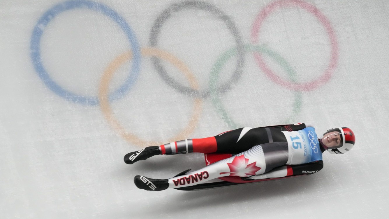 Trinity Ellis slides past Olympic rings on luge track
