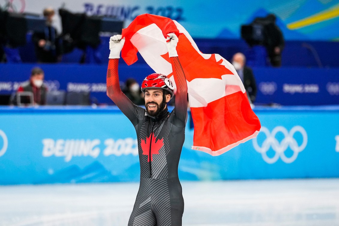 Team Canada short track speed skater Steven Dubois carries flag