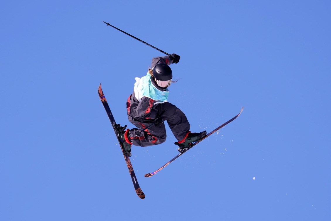 Freestyle skier Olivia Asselin performs a trick in mid-air. She looks like she's running.