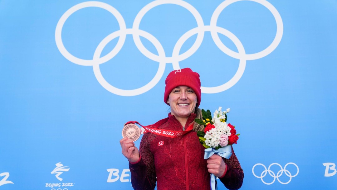 Christine de Bruin poses with her bronze medal in front of Olympic rings