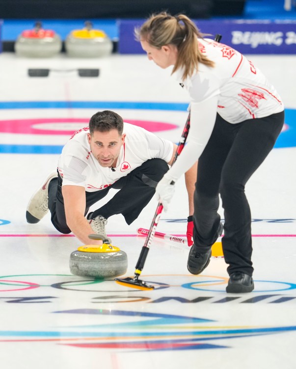 John Morris throws a stone while Rachel Homan sweeps