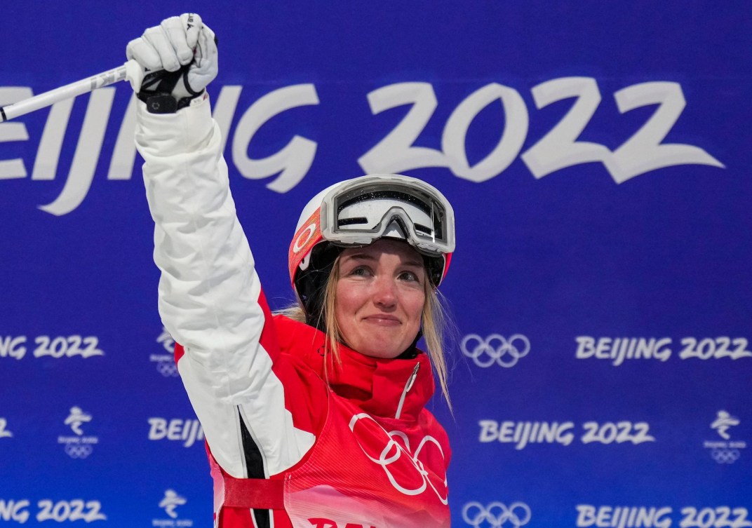 Justine Dufour-Lapointe raises her arm in the finish area while crying