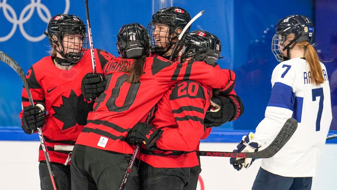 Brianne Jenner #19 of Team Canada celebrates a goal with teammates Claire Thompson #42, Blayre Turnbull #40 and Sarah Nurse #20 as Sanni Rantala #7 of Team Finland skates to the bench during the Beijing 2022