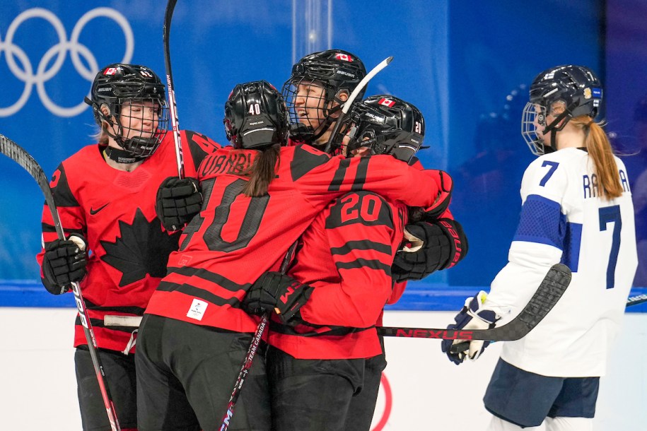 Brianne Jenner #19 of Team Canada celebrates a goal with teammates Claire Thompson #42, Blayre Turnbull #40 and Sarah Nurse #20 as Sanni Rantala #7 of Team Finland skates to the bench during the Beijing 2022