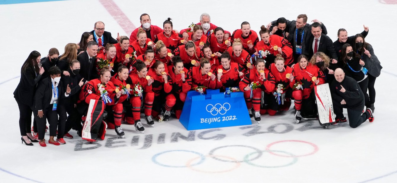 Team Canada women hockey players pose with medals on the ice