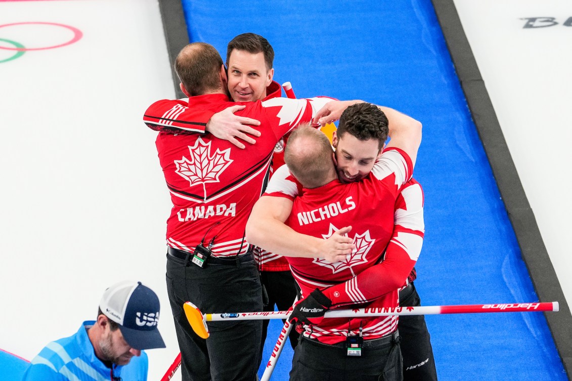 Brad Gushue hugs Geoff Walker and Brett Gallant hugs Mark Nichols