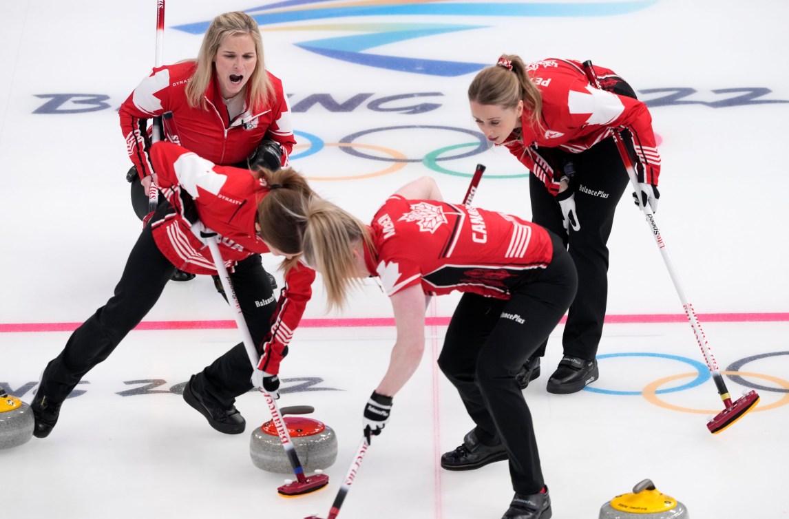 Jennifer Jones yells at her sweepers as they sweep a stone 